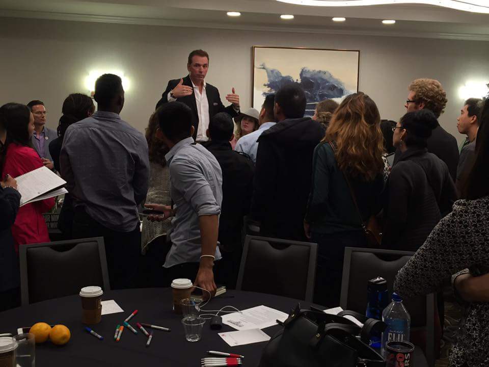 Mike Warren speaking on stage with audience gathered around