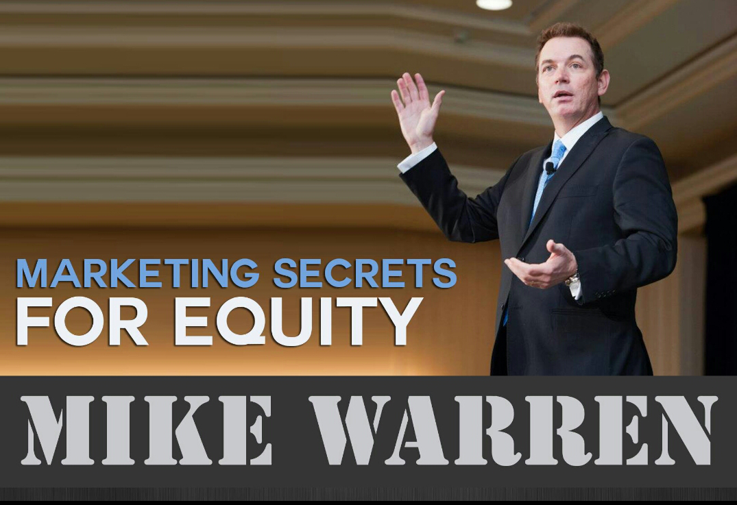 Mike Warren on stage with blue backdrop